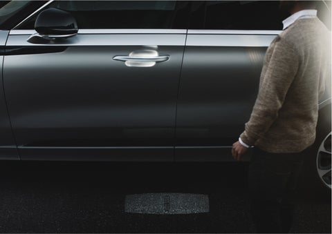 A person approaches a 2023 Lincoln Aviator® Grand Touring as the Lincoln Embrace sequence of welcome lighting illuminates | Gates Lincoln in Richmond KY