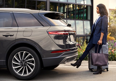 A woman with her hands full uses her foot to activate the hands-free liftgate. | Gates Lincoln in Richmond KY