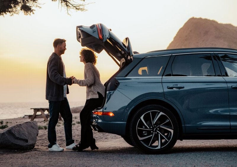 A couple share a moment together outside a 2025 Lincoln Corsair® SUV near the open liftgate. | Gates Lincoln in Richmond KY
