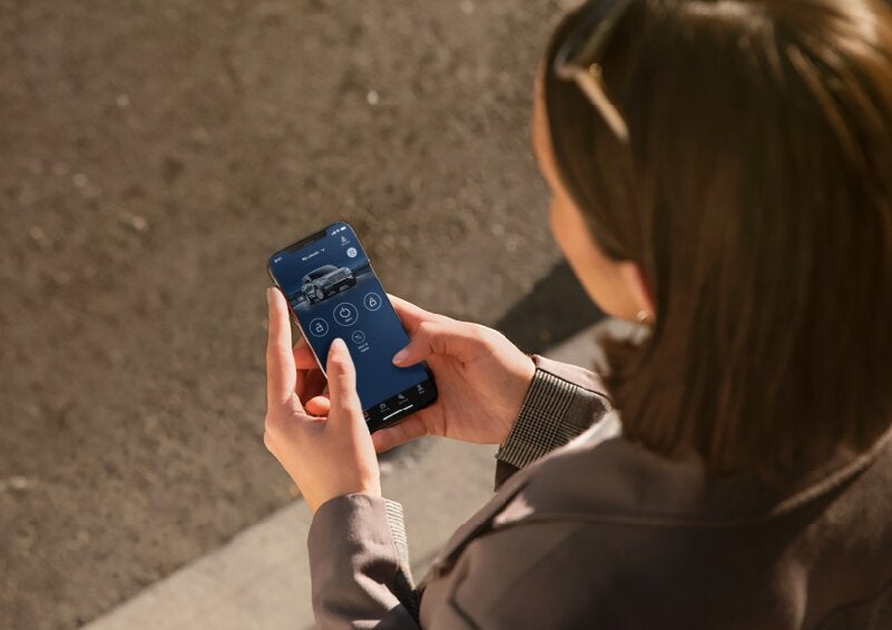 A person is shown interacting with a smartphone to connect to a Lincoln vehicle via the Lincoln Way® App. | Gates Lincoln in Richmond KY