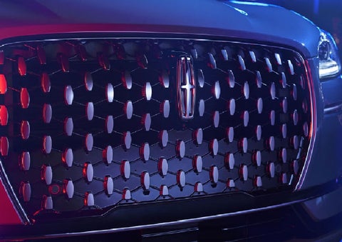 The grille of a 2025 Lincoln Corsair® SUV reflects neon light at night. | Gates Lincoln in Richmond KY