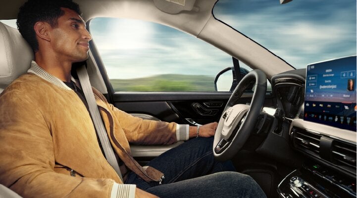 A person is shown using Lincoln BlueCruise hands-free highway driving technology on a divided highway called a Hands-Free Blue Zone. | Gates Lincoln in Richmond KY