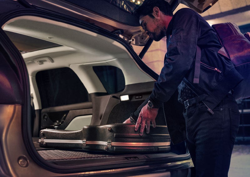 A man is shown loading cargo into the rear of a 2024 Lincoln Corsair® SUV with the second-row seats folded flat. | Gates Lincoln in Richmond KY
