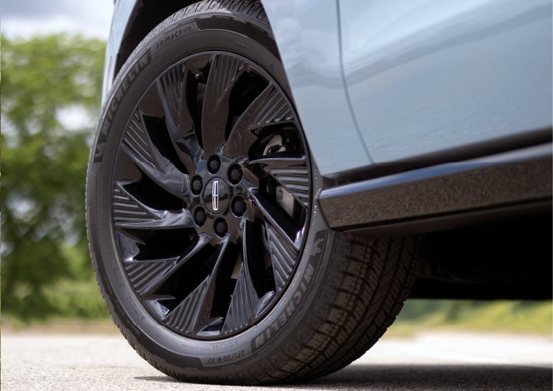 A 2025 Lincoln Navigator® SUV is being driven on a lakeside road.