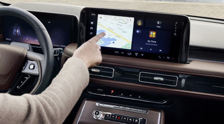 A person is tapping the center display touchscreen of a 2026 Lincoln Aviator® SUV. | Gates Lincoln in Richmond KY