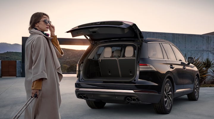A woman approaches a 2026 Lincoln Aviator® SUV with its rear liftgate open. | Gates Lincoln in Richmond KY
